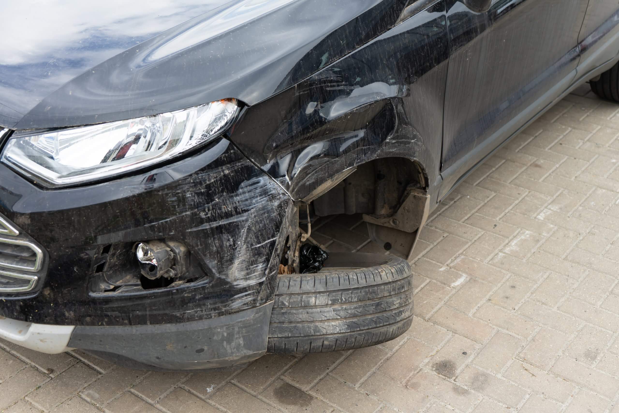 Ein schwarzes Auto mit stark beschädigter Front und abgerissenem Vorderrad, als Automatisch gespeicherter Entwurf markiert